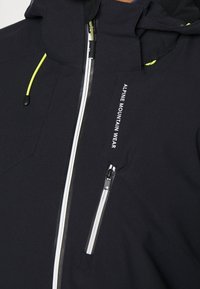 Giacca nera resistente alle intemperie con collo alto, accenti bianchi della zip e branding riflettente. Include una tasca con zip sul petto.
