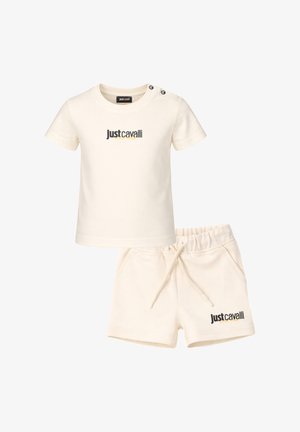 Set per bambini composto da maglietta a maniche corte color crema e pantaloncini, entrambi con il logo "Just Cavalli" e dettagli con bottoni sulla spalla della maglietta.
