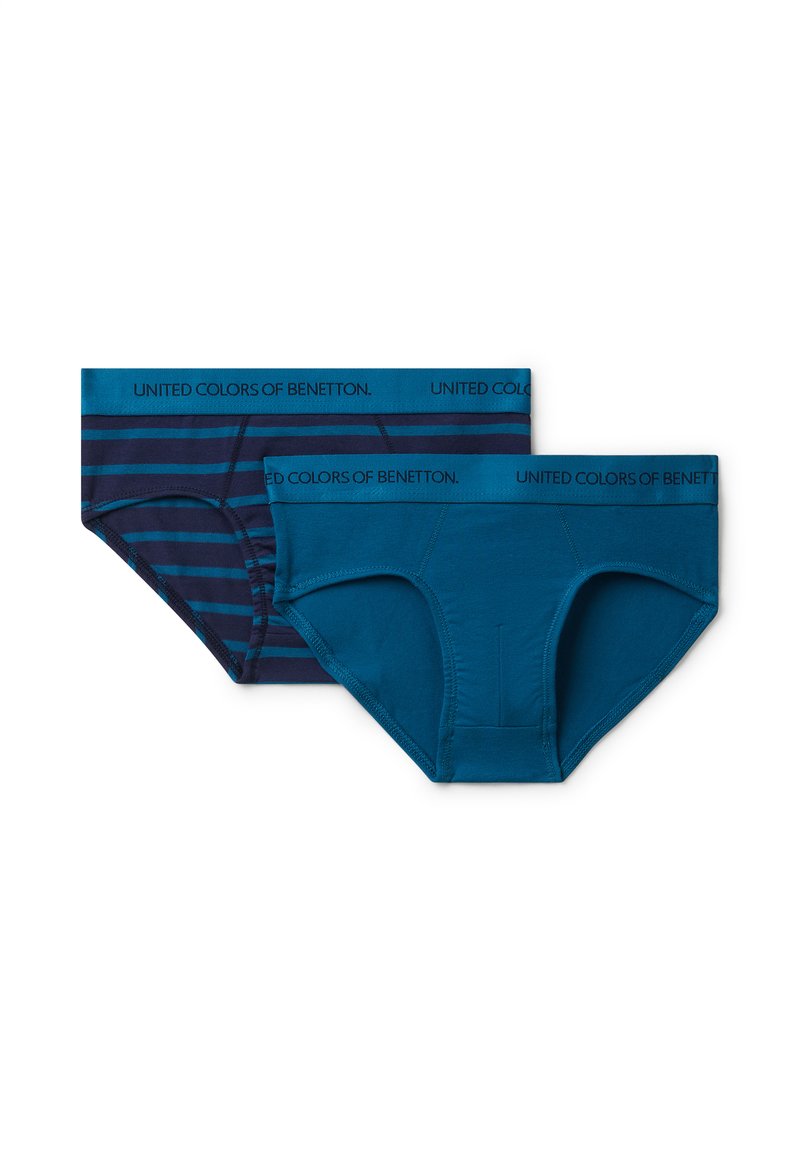 Dvě dvojice modrého spodního prádla: jedny jednobarevné tyrkysové, druhé námořnické s tmavě modrými pruhy. Obě mají gumu s logem "United Colors of Benetton".