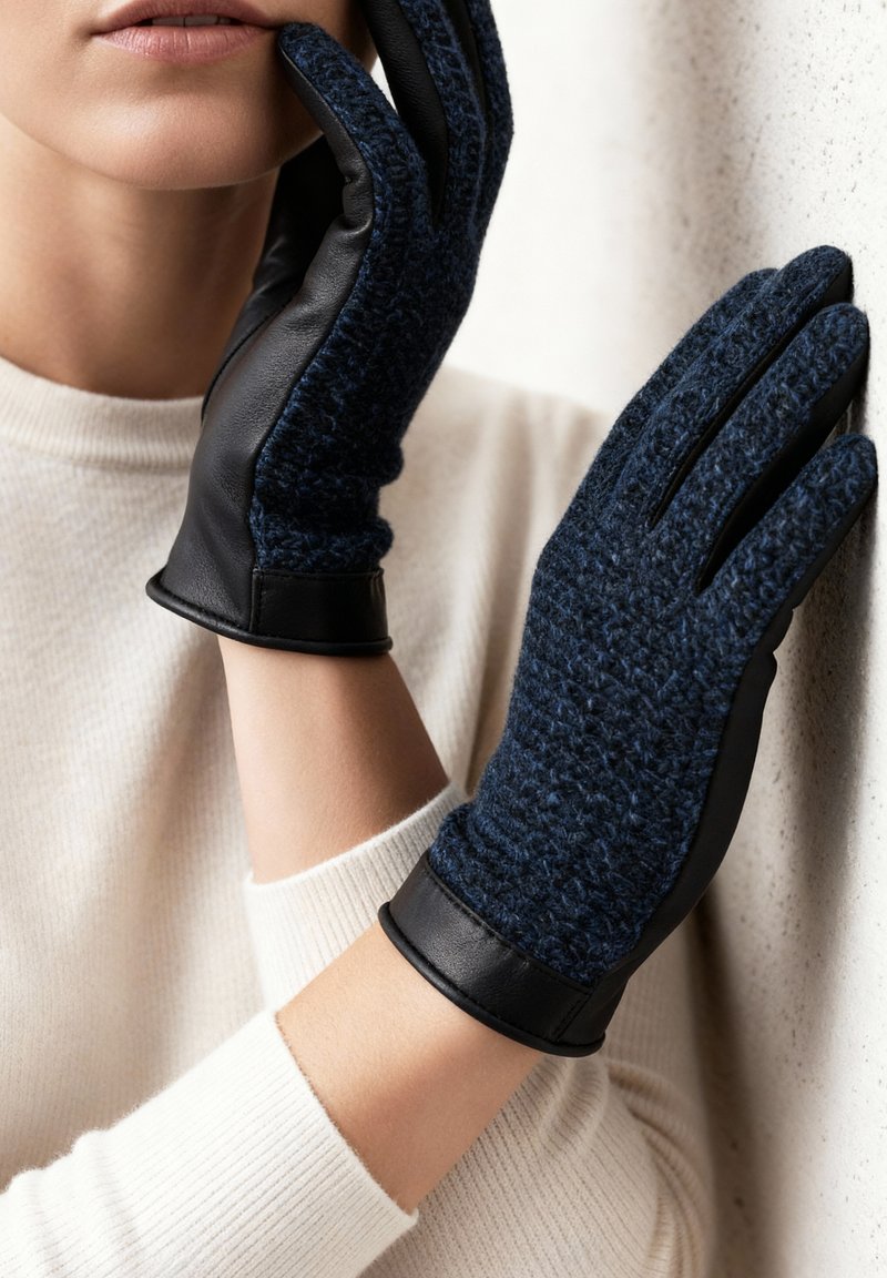 Gants bleu marine avec un dessus en laine texturée et des paumes en cuir noir lisse. Présentent un ajustement serré et une manchette en cuir noir.