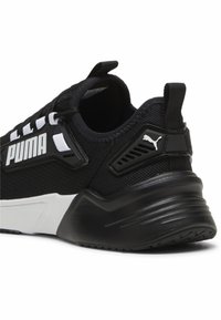 Sneaker de sport noir avec une tige en maille texturée, des bandes blanches en accent, et un contre-fort de talon moulé arborant un logo. Semelle légère pour un amorti.