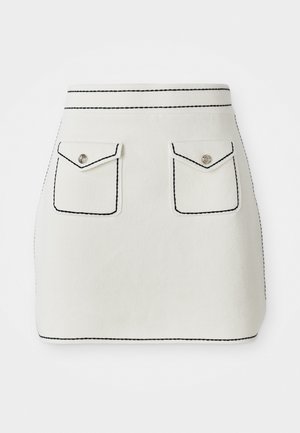 Weißer Minirock aus Stoff mit schwarzem Nähten, ausgestattet mit zwei vorderen Taschen mit Klappen und silbernen Knopf-Details. Glatte Textur mit strukturierter Form.