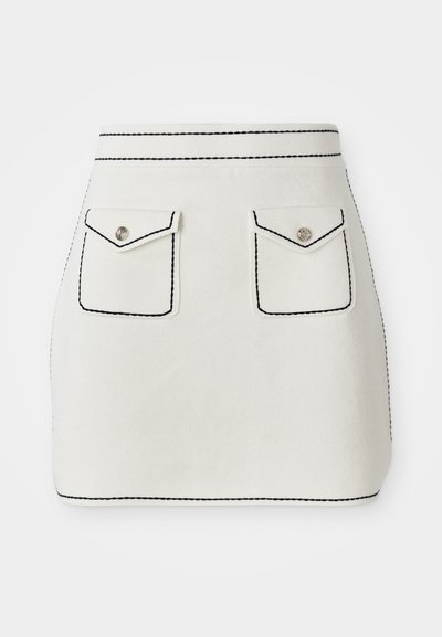 Hvid stof mini nederdel med sort syning, der har to frontlommer med klapper og sølvknap detaljer. Glat tekstur med struktureret form.