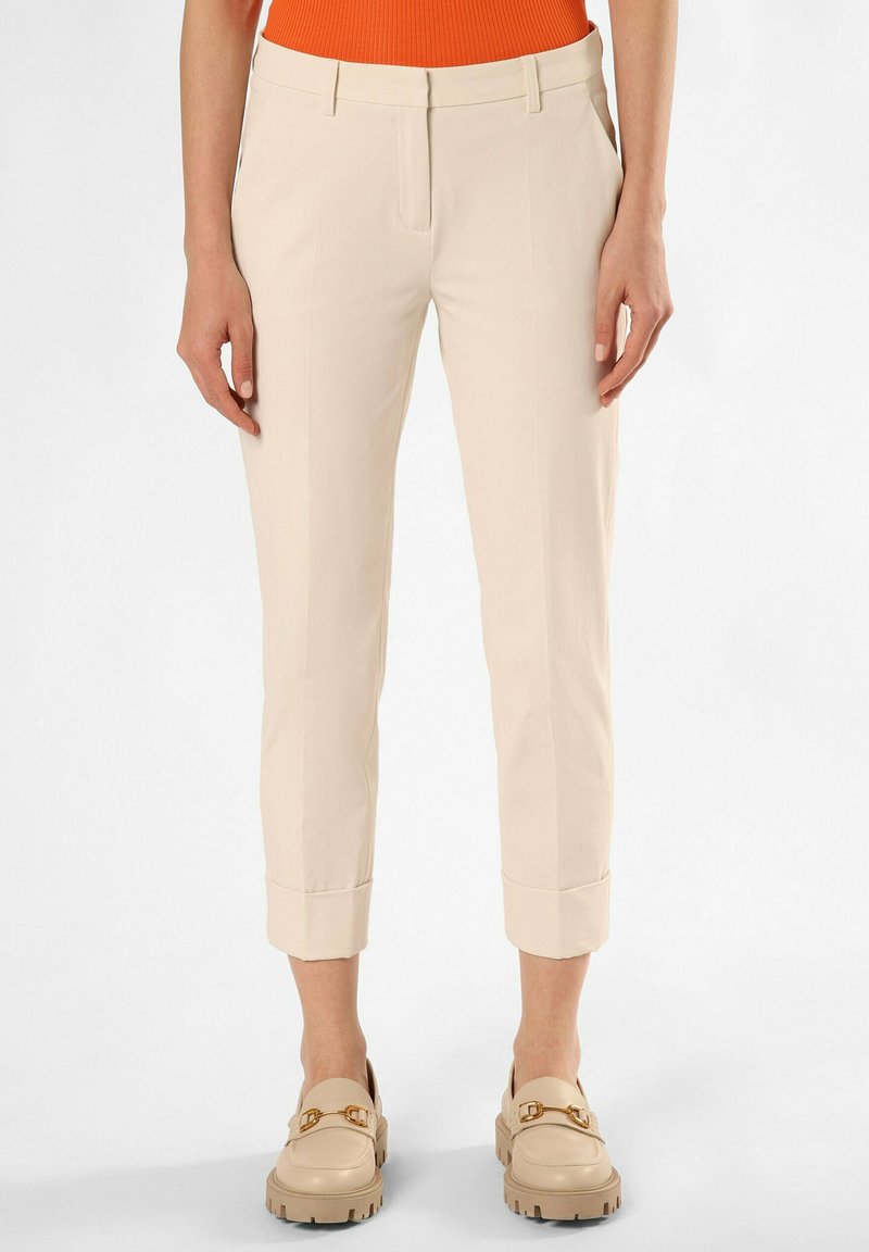 Beige Cropped-Hosen mit glatter Textur, schlankem Schnitt und umgeschlagenen Säumen. Kombiniert mit beigen Schuhen mit goldfarbenen Hardware-Akzenten.