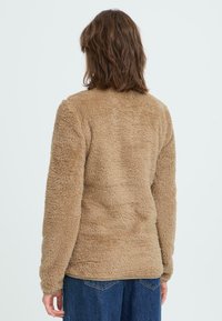Taupe Fleece-Jacke mit einer strukturierten, flauschigen Außenseite, langen Ärmeln und einem runden Ausschnitt, im lässigen Schnitt gestaltet.
