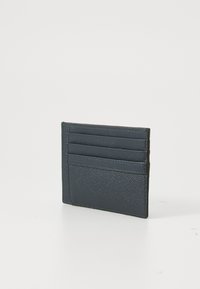 Portafoglio in pelle blu navy con superficie texture, dotato di quattro slot per carte e una tasca laterale, bordi cuciti, forma rettangolare compatta.
