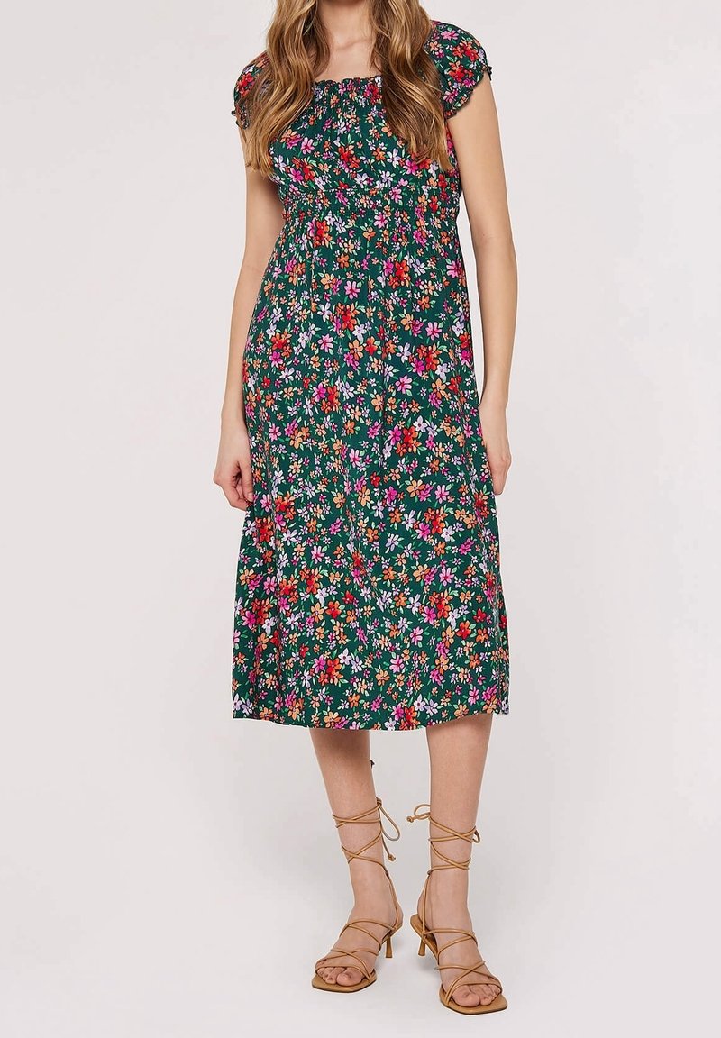 Sukienka w kwiaty na zielonym tle, z krótkimi bufkami i dopasowanym gorsetem. Posiada spódnicę do kolan oraz żywe różowe i fioletowe kwiaty.