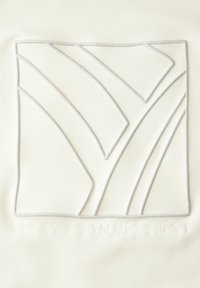 Un tessuto bianco presenta un design quadrato ricamato in rilievo con linee curve e il testo "STAY CONNECTED" impressa sottostante.