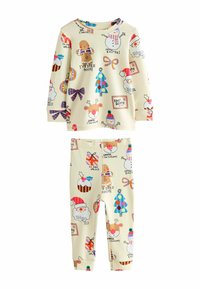 Pigiami a maniche lunghe in crema realizzati in morbido materiale, con fantasie colorate a tema natalizio che includono omini di pan di zenzero, pupazzi di neve, alberi di Natale e regali.