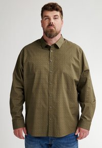 Camicia a maniche lunghe con bottoni in tessuto verde oliva, decorata con un sottile motivo geometrico, dotata di colletto a punta e chiusura frontale con bottoni.