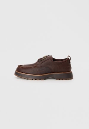 Brown leather shoes with a textured finish, sturdy tread sole, and rounded toe. Features metal eyelets and a contrasting brown midsole.