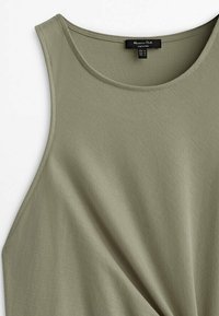 Débardeur vert olive en tissu doux, avec un col rond et un détail torsadé sur le devant, présentant une texture lisse.