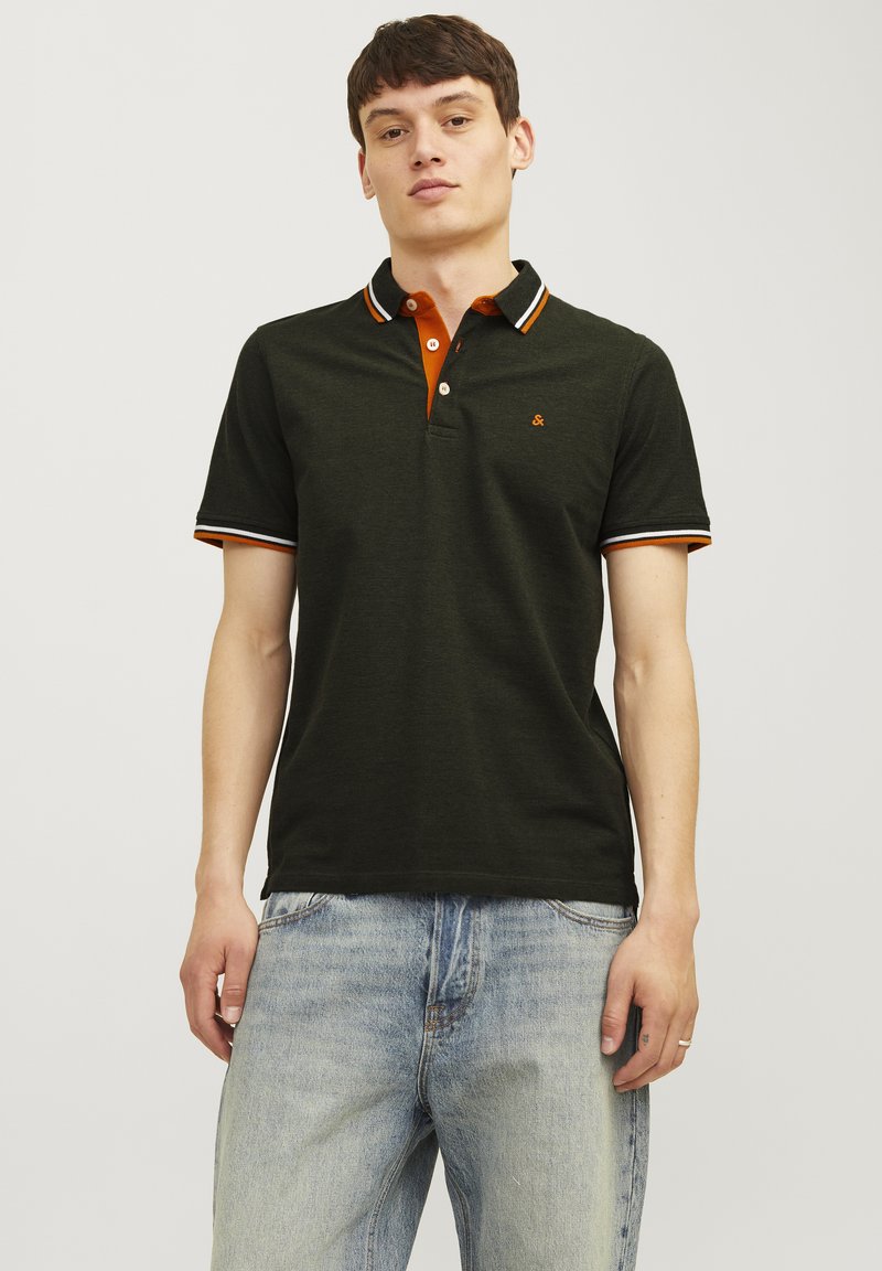 Donkergroene polo met oranje accenten op de kraag en mouwen, voorzien van een knoopsluiting en een klein logo op de borst.