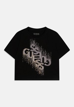 Camiseta negra de manga corta y corte cropped con el logo "GUESS" hecho de brillantes pedrería en un patrón diagonal en la parte frontal.