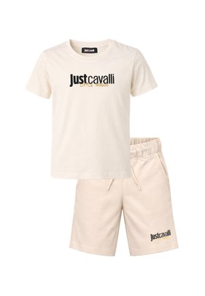 Completo con t-shirt beige a maniche corte e pantaloncini, con la stampa "Just Cavalli Little Rogue" in nero e oro su entrambi i capi.