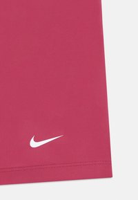 Fuchsia Nike-Shirt, glattes Material, kurze Ärmel, mit einem weißen Nike-Logo in der unteren linken Ecke, gesticktes Saumdetail.