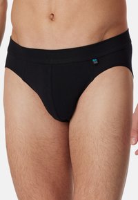 Schwarze Baumwollunterhosen mit einem breiten elastischen Bund, der ein kleines Logo auf der linken Vorderseite aufweist, und einem engen Sitz für Komfort.