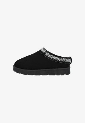 Schwarzer Wildlederschuh zum Hineinschlüpfen mit einer dicken Gummisohle, der weiße Zierstiche entlang des Kragens und eine kleine Schlaufe hinten aufweist.