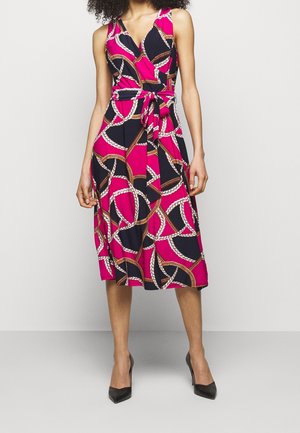 Ärmelloses Wickelkleid mit rosa, schwarzem und weißem Seilmuster, in der Taille gebunden, getragen mit schwarzen High Heels.