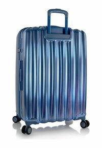 Blue hardshell suitcase with vertical ridges, textured finish, retractable handle, four wheels, and zipper closure.