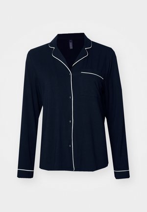 Chemise de pyjama à manches longues navy avec piping blanc, devant à boutons et poche poitrine. Fabriquée à partir d'un tissu doux et léger.