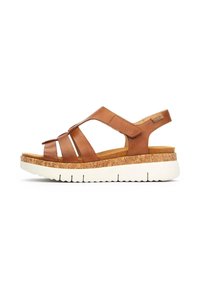 Sandalias de cuero marrón con suela de corcho, que cuentan con una entresuela blanca, tiras ajustables y un diseño casual. La vista lateral muestra la colocación de las tiras.