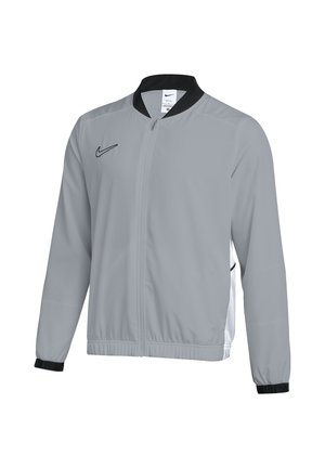 Graue Nike Zip-Up Jacke mit schwarzem Kragen und Bündchen, langen Ärmeln und schwarzem Nike-Logo auf der Brust und seitlichen Mesh-Einsätzen.