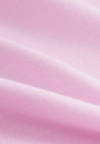 Tissu rose clair avec une texture lisse, présentant des nervures fines et un éclat subtil, capturé en plis doux et superposés.