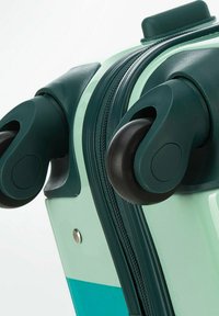 Valigia rigida con un design verde menta e teal, dotata di ruote nere lisce, chiusura a zip e un piccolo dettaglio in metallo.