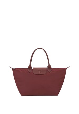 Medium-sized maroon tote bag with leather handles, leather flap, and silver zipper closure, designed for casual or travel use.