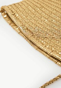 Geweven gouden clutch tas met een gestructureerd oppervlak. Voorzien van metalen accenten en een gevouwen ontwerp, dat een gevlochten schouderband toont.