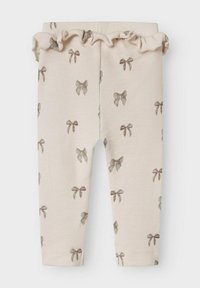 Pantalons en crème à côtes avec une taille volantée, mettant en avant un motif de noeuds répété dans des couleurs douces, conçus pour le confort et le style.