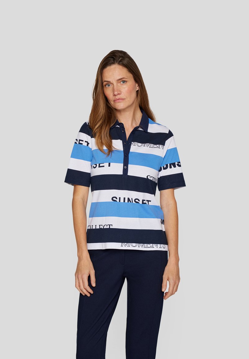 Polo-Shirt aus Baumwollmischung, mit horizontalen Streifen in Blau, Weiß und Marine, auf dem der Text "SAMMLE SONNENUNTERGANGSMOMENTE" gedruckt ist.