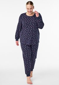 Marinblå pyjamasset med långärmad topp och byxor, med små rosa och vita hjärtan, mjukt bomullsmaterial och ledig passform.