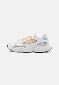 White athletic shoe with mesh and synthetic materials, featuring orange accents, three-striped design, rounded toe, and textured sole.