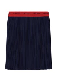 Námořnická skládací sukně s červeným elastickým pasem, na kterém je černě vyvedený nápis "LACOSTE". Vyznačuje se úhlednými, jednotnými sklady a jemnou texturou.