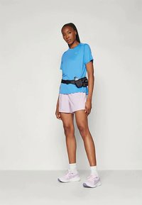 Sinine lühikeste varrukatega spordipoliit, heledad lillad lühikesed püksid, must vöökott, valged pahkluud sokid ja heledad roosad spordijalatsid lilla aktsentidega.