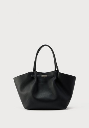 Bolso tote de cuero negro con textura de grano, con dos correas para el hombro y un pequeño cierre rectangular plateado en la parte frontal sobre un fondo blanco liso.