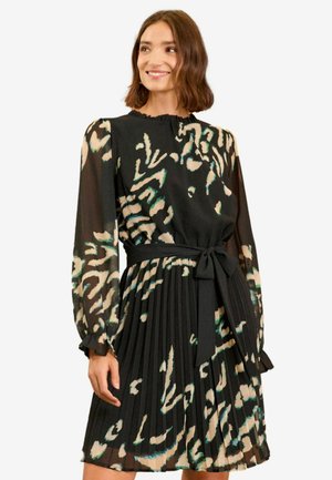 Musta pleated-mekko pitkilla hihoilla, teksturoidusta kankaasta, jossa on vihreä ja beige abstrakti kuvio, ja vyötäröllä yhteensopiva vyö.