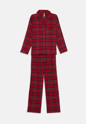 Röd rutigt pyjamas-set gjort av mjuk bomull. Har långa ärmar, knäppning framtill, bröstficka och löst sittande byxor med elastisk midja.