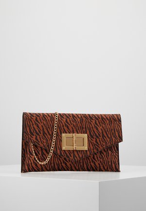 Pochette rectangulaire à rayures tigre marron et noir avec fermoir rectangulaire doré et chaîne dorée attachée, posée sur une surface blanche.