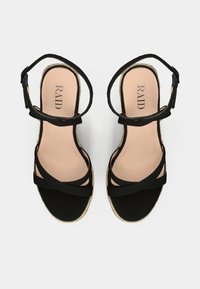 Mustad espadrillid ristirihmadega, pehme jalanõu sisu ja jute-mähisega vahevaip. Sile sisetald brändi nime trükiga.