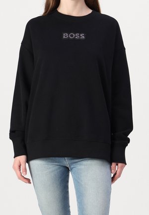 Zwarte sweatshirt met ronde hals, losse pasvorm, lange mouwen en geribbelde manchetten. Voorzien van een textuur "BOSS" logo in zilveren accenten aan de voorkant.