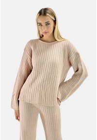 Suéter de punto acanalado en color rosa claro, con mangas largas y escote ancho, combinado con pantalones de punto acanalado a juego. Textura suave, corte relajado.