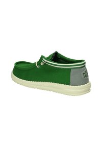Scarpa da barca in tela verde con suola in gomma bianca, tacco grigio a contrasto e lacci grigi. Presenta un design cucito e una forma a taglio alla caviglia.