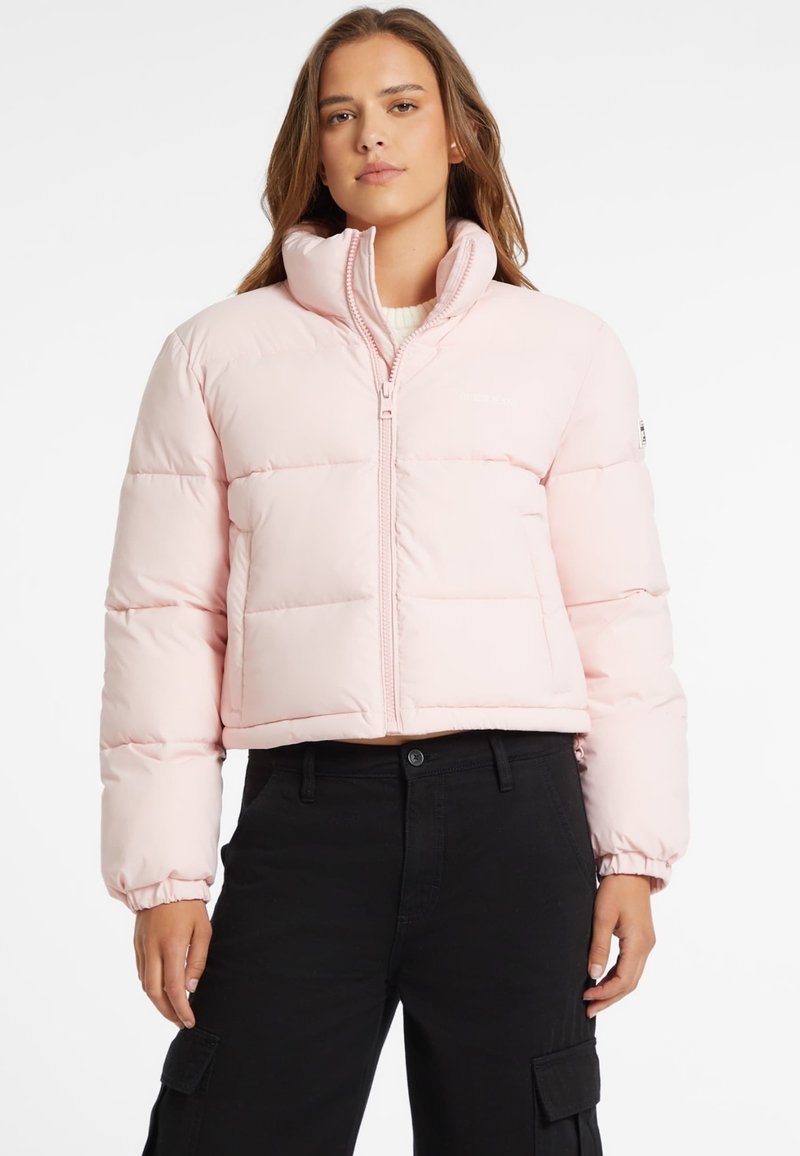 Šviesiai rožinė trumpa pūkinė striukė, su siuvinėtu raštu, aukštu apykakle, priekyje su užtrauktuku, elastingomis rankogaliais, derinama su juodomis kelnėmis. Paprastas ir funkcionalus stilius.