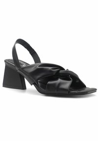 Mustat nahkaiset slingback-sandaalit solmittu design ja kolmion muotoinen korokepohja. Sujuva pinta, jossa on tasapohja ja avoin varvas.