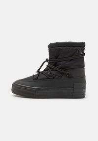 Černá kotníková bota s prošívaným nylonovým svrškem, gumovou podrážkou a zvýšenou platformou. Obsahuje design šněrování s toggle knoflíky a logo na boku.