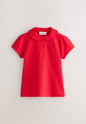 Polo per bambini a maniche corte di colore rosso con colletto arrotondato, tre bottoni a forma di cuore e etichetta Clarks all'interno del collo.