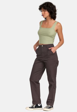 Olivgrön ribbade croptop parat med mörkbruna högmidjade cargobyxor med sidofickor och rak bendesign. Svarta sneakers.
